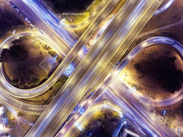 istock Highway elevated road intersection traffic night long exposure vehicle light trail aerial top down shot 1045360782