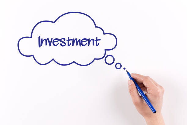 istock Hand writing Investment on white paper, View from above 1045368270