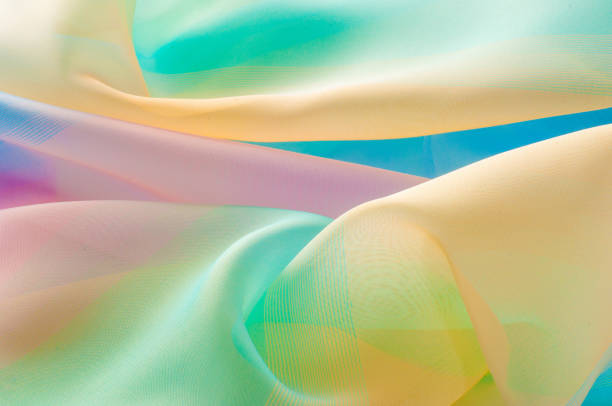 istock Texture, background, pattern. Silk fabric is transparent, yellow-pink green in blue. Abstract soft chiffon texture background. 1045371880