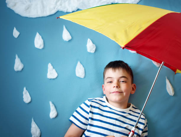 istock Little boy on blue background in coat with drop shapes 1045372864