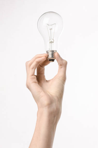 istock Energy consumption and energy saving topic: human hand holding a light bulb on a white background in studio 1045387492