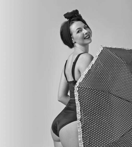 Woman in black bikini with umbrella . Middle age woman in black bikini with umbrella . Beautiful woman in pin up style with perfect hair and make up .Expressive facial expressions. Black and white. pin up girl photos stock pictures, royalty-free photos & images