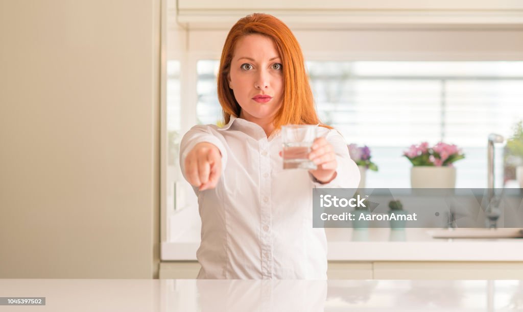 Durstig rothaarige Frau und Glas Wasser zeigt mit Finger auf die Kamera und Sie Hand unterzeichnen, positiv und zuversichtlich Geste von vorne - Lizenzfrei Anführen Stock-Foto