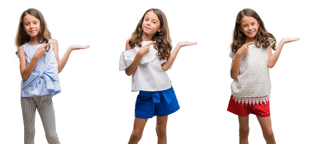 Collage of hispanic young child over isolated background amazed and smiling to the camera while presenting with hand and pointing with finger.