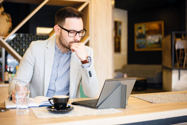 istock Young businessman checking daily agenda on a tablet while working in a modern coffee shop 1045408294