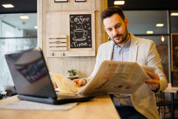 istock Young architect or businessman reading newspapers while on a break in a cafe 1045409062