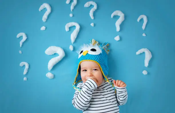 Photo of little boy with lots of question marks
