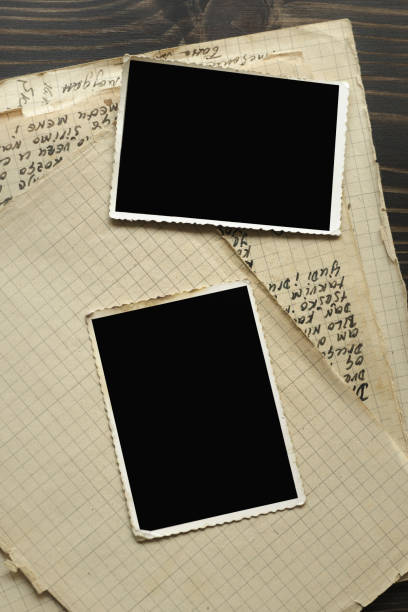 istock Notebook with old frame photo on wood table background 1045414448