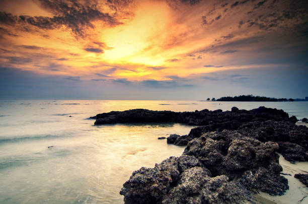 istock stunning sunset sunrise  scenery with unique shape rock formation and waves splashing. soft focus due to long exposure shot 1045419874