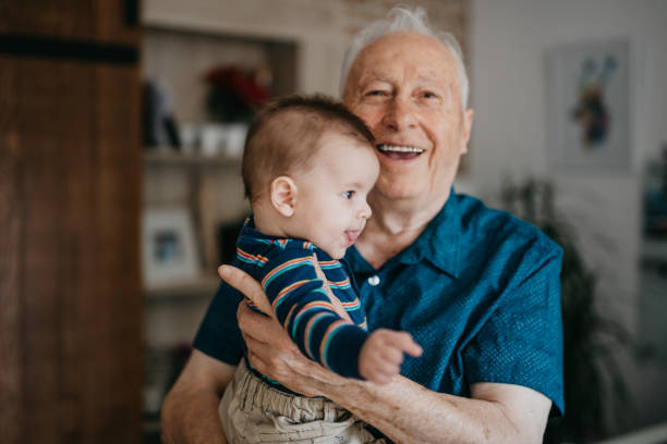 istock Smiling grandpa holding his grandchild 1045421122