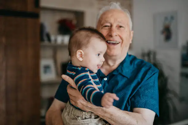 Smiling grandpa holding his grandchild