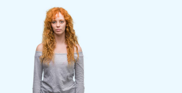 istock Young redhead woman with serious expression on face. Simple and natural looking at the camera. 1045421172