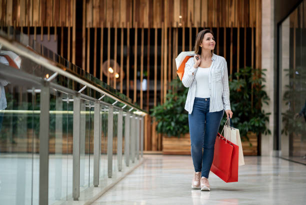 happy shopping woman holding bags at the mall - christmas shopping imagens e fotografias de stock