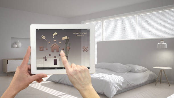 istock Smart remote home control system on a digital tablet. Device with app icons. Minimalist modern bright bedroom in the background, architecture interior design 1045425872