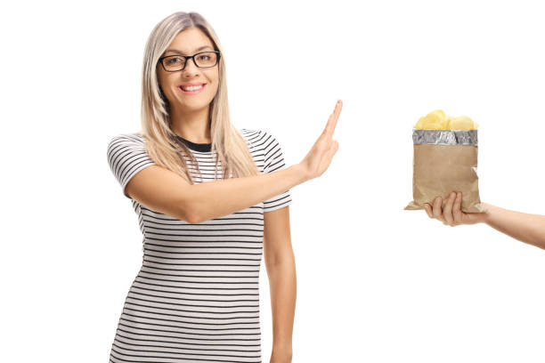 istock Young woman refusing a bag of potato chips 1045425902