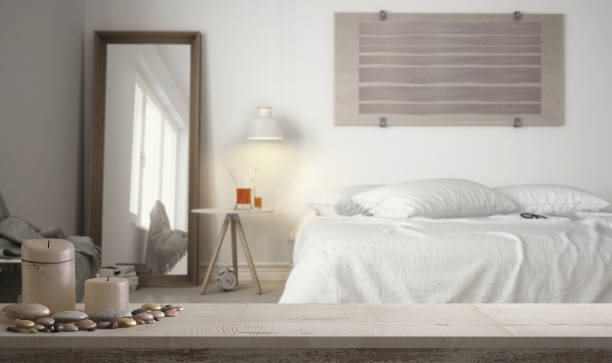 деревянный винтажный столешницу или полку со свечами и галькой, дзен настроение, более размыты минималистский белый спальня, современный д - pebble bed стоковые фото и изображения