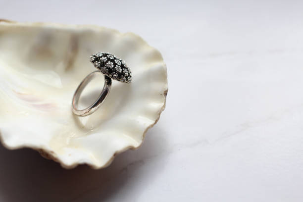 istock silver ring with precious stones on a shell, marble background 1045427560