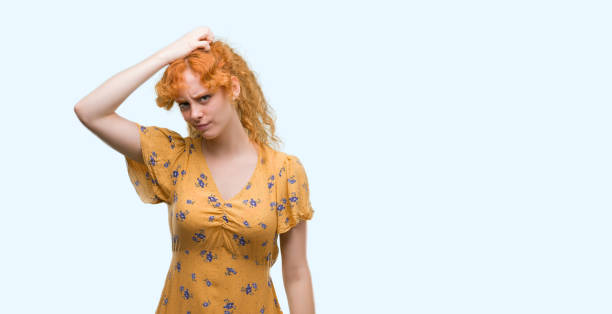 istock Young redhead woman confuse and wonder about question. Uncertain with doubt, thinking with hand on head. Pensive concept. 1045431256