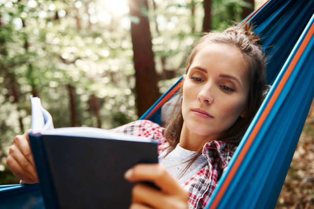 istock Woman relaxing on hammock and reading a book 1045435556