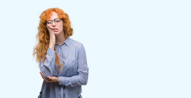 istock Young redhead bussines woman thinking looking tired and bored with depression problems with crossed arms. 1045437926