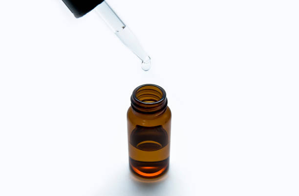 istock Chemical liquid drop was dropping into a brown bottle by a syringe 1045438116