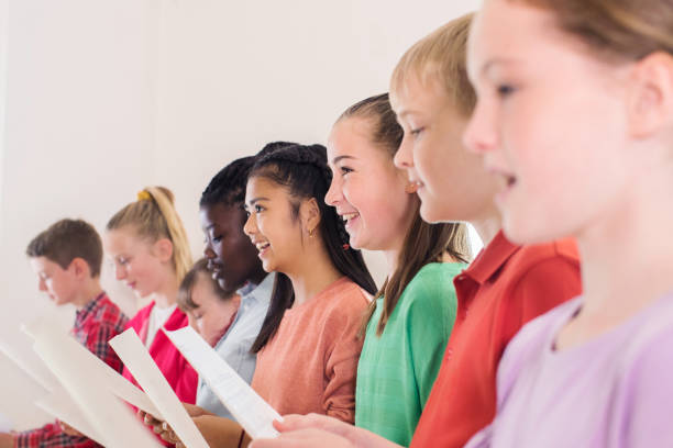 grupo de crianças da escola em coro cantar junto  - sheet music music classroom education - fotografias e filmes do acervo