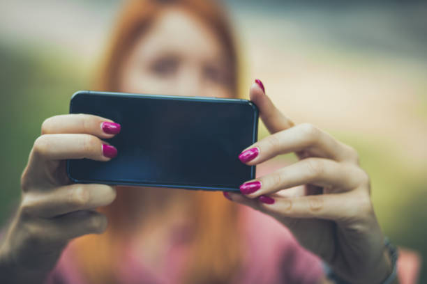 istock Woman making a self portrait . Focus is on hands. 1045442774