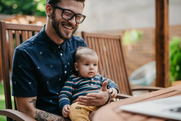 padre e hijo con chat de video en un patio trasero - playing playful baby contemporary fotografías e imágenes de stock