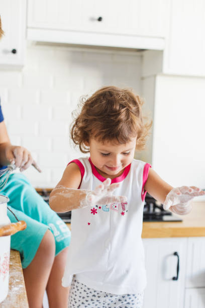 istock Brother and sister preparing dough for pancakes at the kitchen. 1045454268