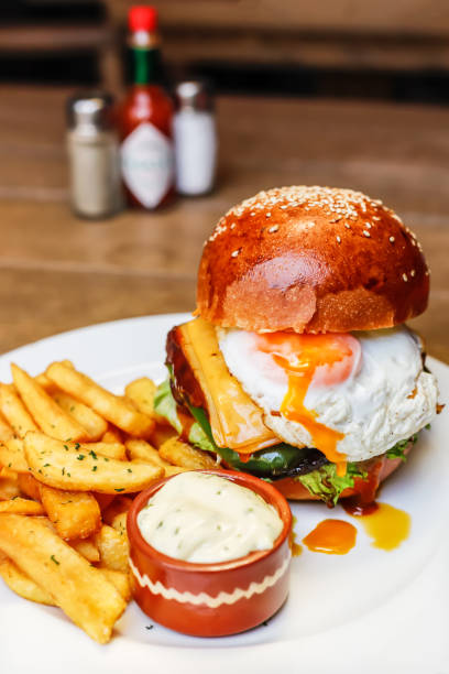 istock Burger with dripping egg yolk and fries 1045454736