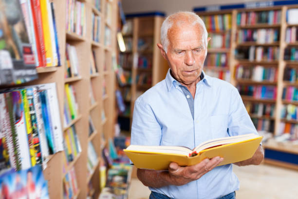 istock Focused elderly man looking for information in books in bookstore 1045454926