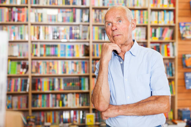 istock Pensive senior man standing in library 1045454932