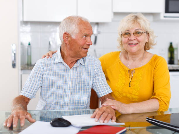 istock Happy mature couple with documents sitting at table in home 1045455328