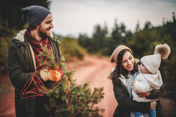 istock Happy parents with their daughter picking out a Christmas tree 1045457726
