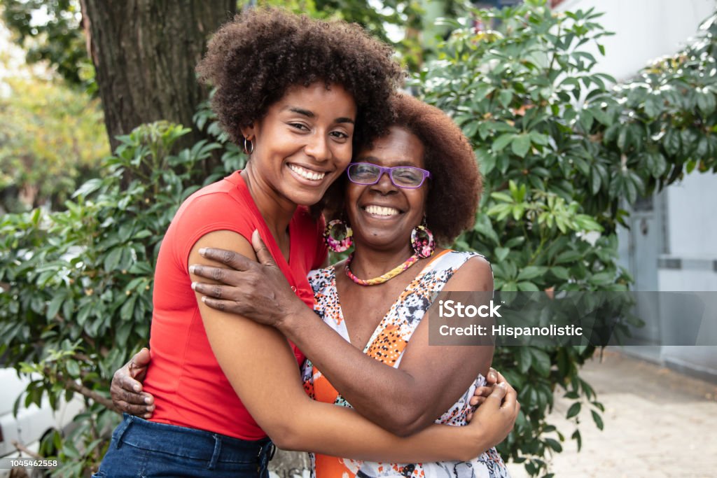 Portrait of beautiful mother and daughter embracing each other while looking at camera with a toothy smile Portrait of beautiful mother and daughter embracing each other while looking at camera with a toothy smile very happy Mother Stock Photo