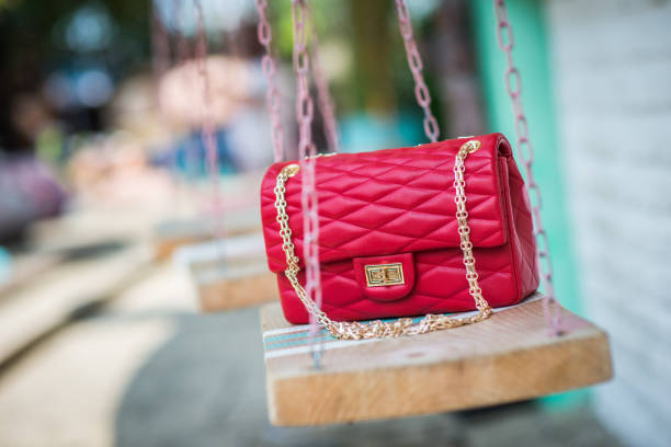 istock Bright red leather handbag on vintage swing 1045462722