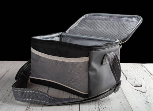 istock side view grey and black lunch pack carrier on a wood table on black background with the top open 1045462790