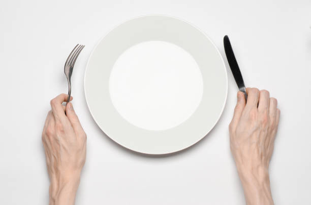 istock Restaurant and Food theme: the human hand show gesture on an empty white plate on a white background in studio isolated top view 1045465500