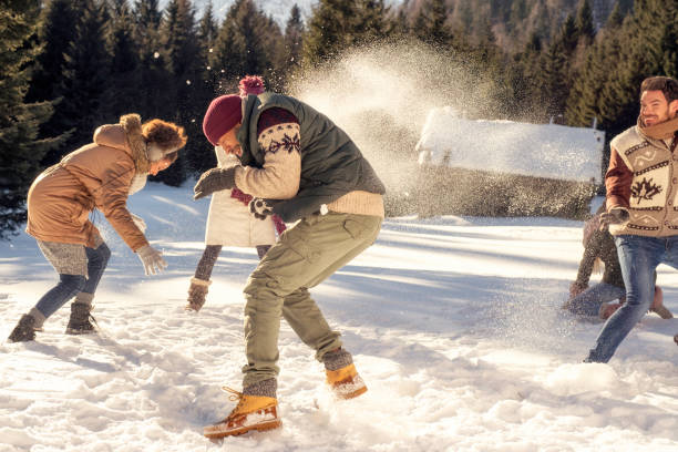 istock Young adults throwing snowballs at each other 1045465538
