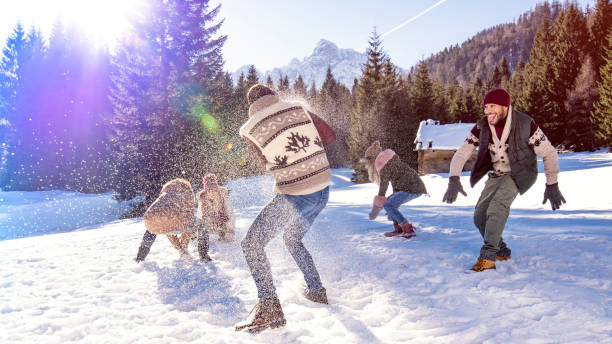 istock Young adults throwing snowballs at each other 1045465542