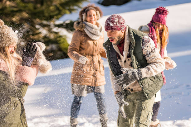 istock Man throwing a snowball at a girl's face 1045465544