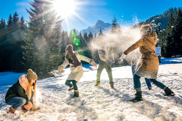 istock Group of young people playing with snow in nature 1045465552