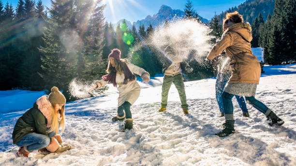 istock Young adults throwing snowballs at each other 1045465554