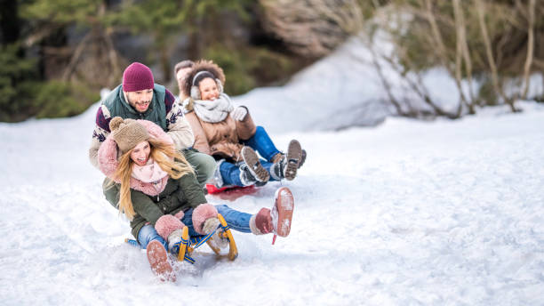 istock Multi-ethnic couples riding on the snow in sleds 1045465574