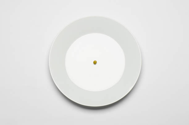 istock Healthy eating topic: green peas lying on a white plate on a white table in the studio top view 1045465762