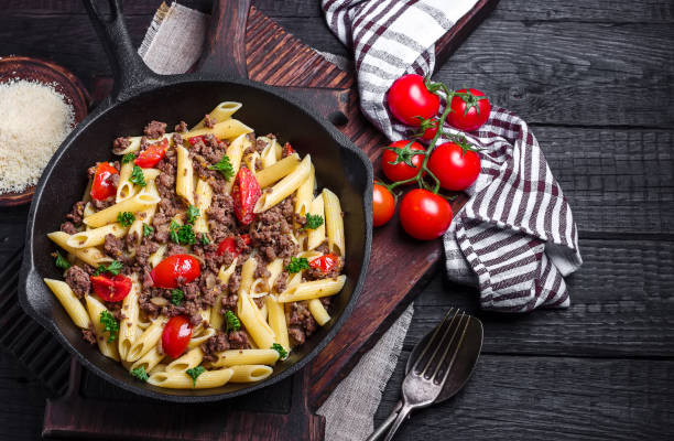 istock Pasta with tomatoes and meat on  dark rustic background. 1045467058