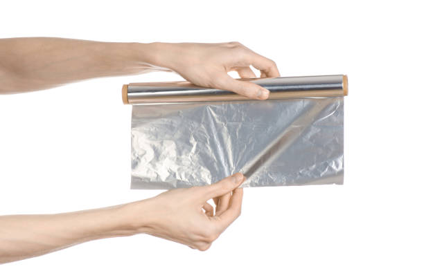 istock Cooking and shisha topic: human hand holding a foil isolated on white background in studio 1045467184