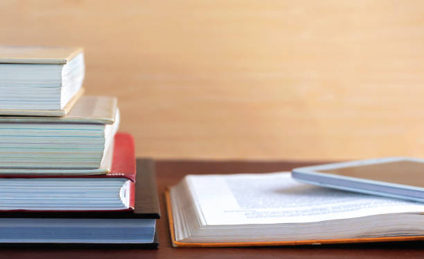 istock Open textbook and notepad on the table. The concept of combining learning in the past and present. 1045469994