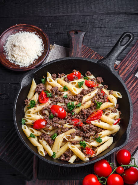 istock Pasta with tomatoes and meat on  dark rustic background. 1045470138