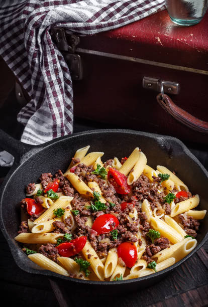 istock Pasta with tomatoes and meat on  dark rustic background. 1045470640